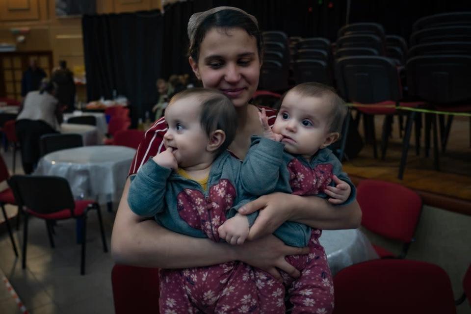 Una mujer carga a sus dos ni&#xf1;os peque&#xf1;os en una iglesia de Khmelnytskyi (Bel Trew)