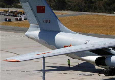 A member of the personnel stands under a Chinese Air Force Ilyushin Il-76 aircraft used in the search for Malaysia Airlines flight MH370 upon its return from its mission at Perth International Airport March 27, 2014. REUTERS/Jason Reed