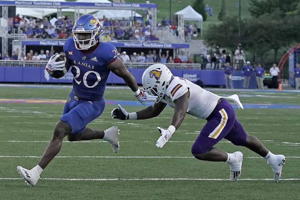 Kansas running back Daniel Hishaw Jr. (20) gets past Tennessee Tech defensive back Josh Reliford to score a touchdown during the first half of an NCAA college football game against Tennessee Tech Friday, Sept. 2, 2022, in Lawrence, Kan. (AP Photo/Charlie Riedel)