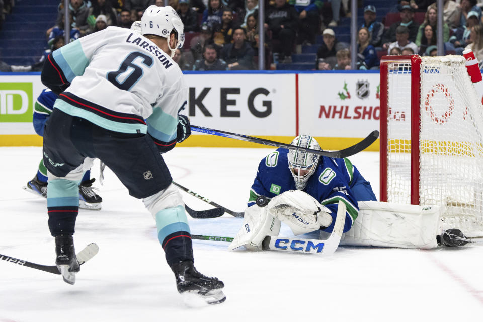 Vancouver Canucks goaltender Thatcher Demko (35) stops Seattle Kraken's Adam Larsson (6) during the third period of an NHL hockey game Saturday, Nov. 18, 2023, in Vancouver, British Columbia. (Ethan Cairns/The Canadian Press via AP)