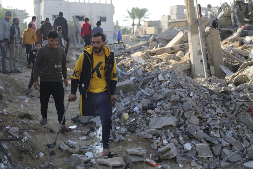 Palestinians look at the destruction by the Israeli bombardment of the Gaza Strip in Rafah, Monday, Dec. 4, 2023.