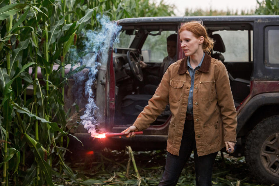 Woman by a truck holding a fiery weapon