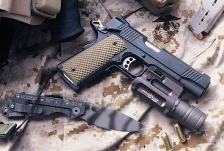 One of Detachment One's Kimber M1911 variants, along with a Strider SMF knife specially made for the unit. <em>USMC</em>