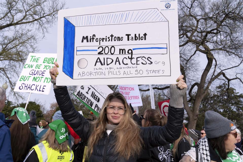 FILE - Abortion-rights activists holds a signs as they protest outside of the Supreme Court during a rally, March 26, 2024, in Washington. A new survey puts a number to how often medical providers in states with laws that seek to protect them from prosecution are prescribing abortion pills to women in states with abortion bans or limits on prescribing the bills by telehealth. (AP Photo/Jose Luis Magana, file)