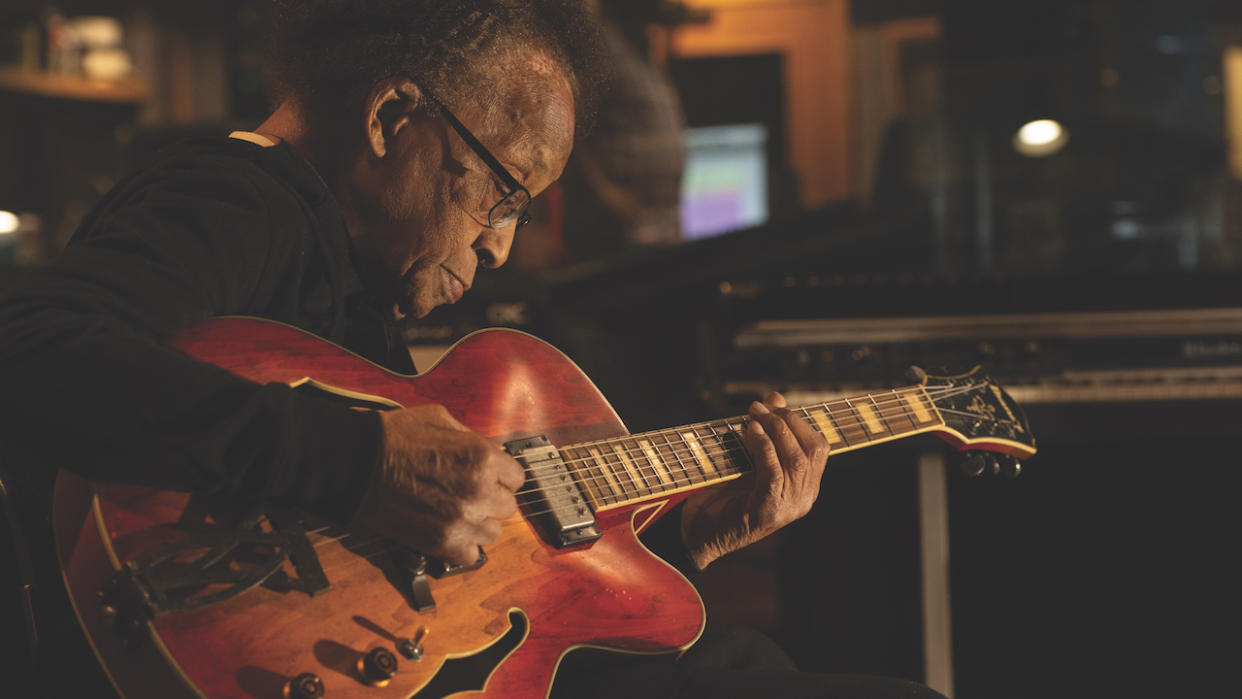  Portrait-style shot of jazz guitarist George Freeman playing guitar in a recording studio. 