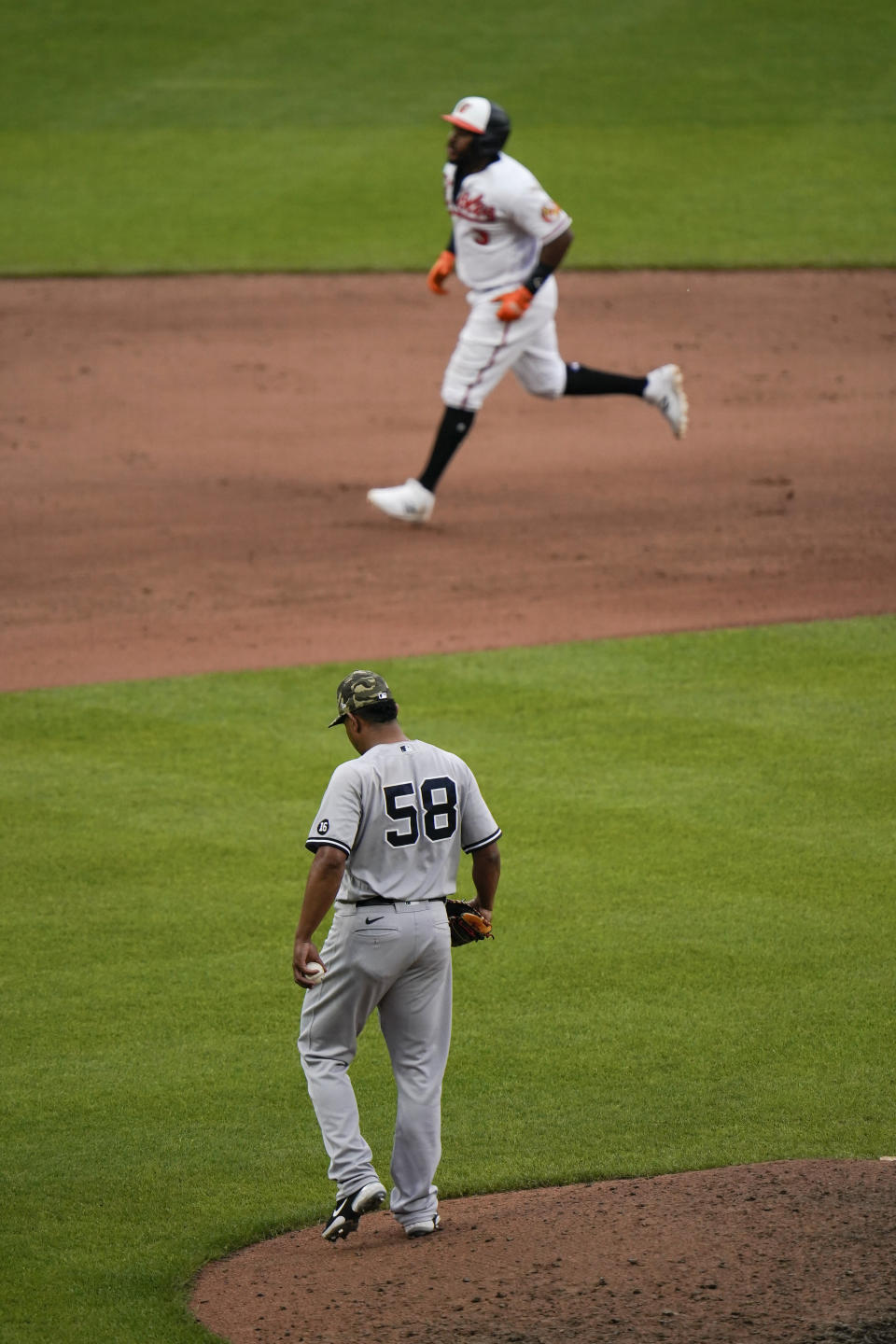 Baltimore Orioles' Maikel Franco, top, runs the bases after hitting a two-run home run off New York Yankees relief pitcher Wandy Peralta (58) during the seventh inning of a baseball game, Sunday, May 16, 2021, in Baltimore. Orioles' Pedro Severino scored on the play. (AP Photo/Julio Cortez)