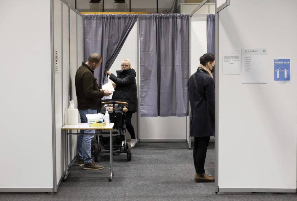 People vote at a local sports complex in Kopavogur, Iceland, Saturday, Sept. 25, 2021. Icelanders are voting in a general election dominated by climate change, with an unprecedented number of political parties likely to win parliamentary seats. (AP Photo/Arni Torfason)