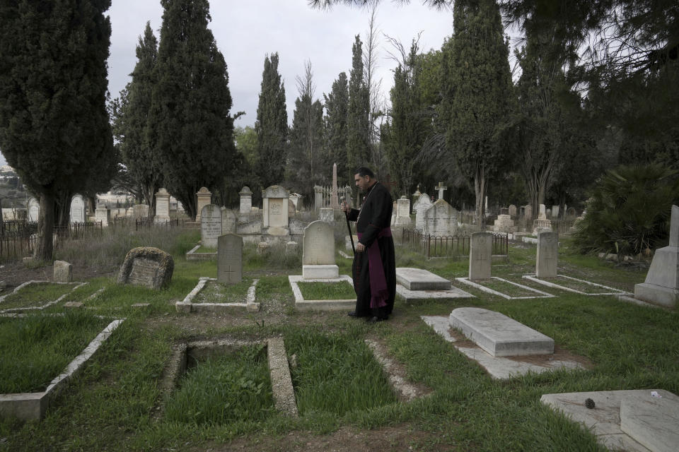 Hosam Naoum, a Palestinian Anglican bishop, walks where vandals desecrated more than 30 graves at a historic Protestant Cemetery on Jerusalem's Mount Zion in Jerusalem, Wednesday, Jan. 4, 2023. Israel's foreign ministry called the attack an "immoral act" and "an affront to religion." Police officers were sent to investigate the profanation. (AP Photo/ Mahmoud Illean)