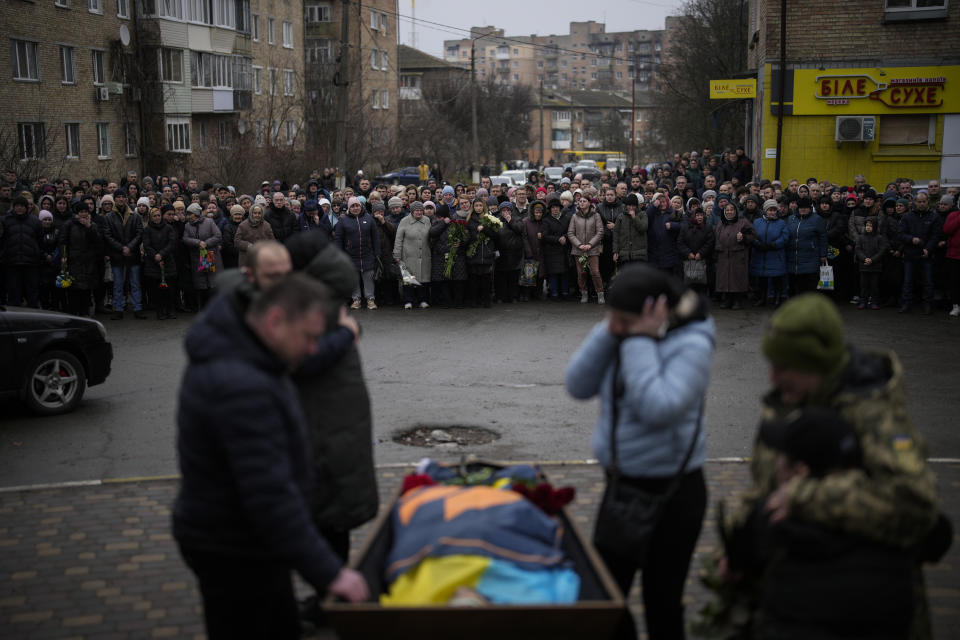 Bucha relatives gather to mourn the body of Oleksiy Zavadskyi, a Ukrainian serviceman who died in combat on January 15 in Bakhmut, during his funeral in Bucha, Ukraine, Thursday, Jan. 19, 2023. This past week has been an especially tragic one for Ukraine. A barrage of Russian missiles struck an apartment complex in the southeastern city of Dnipro on Jan. 14, and the death toll from that attack rose steadily in the days that followed, with at least 45 civilians killed, including six children. Then on Wednesday, a government helicopter carrying the interior minister and other officials crashed into a building housing a kindergarten in a suburb of Kyiv. (AP Photo/Daniel Cole)