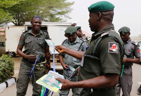 A police officer hands out security tags during the distribution of election materials at the INEC office in Yola, Adamawa State, ahead of the country's presidential election, in Yola, Nigeria February 15, 2019. REUTERS/Nyancho NwaNri