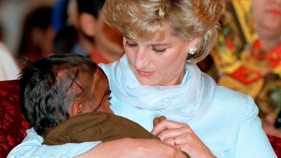 Diana comforts a child during a visit to Imran Khan's Cancer Hospital in Lahore, Pakistan in April 1996. - Anwar Hussein