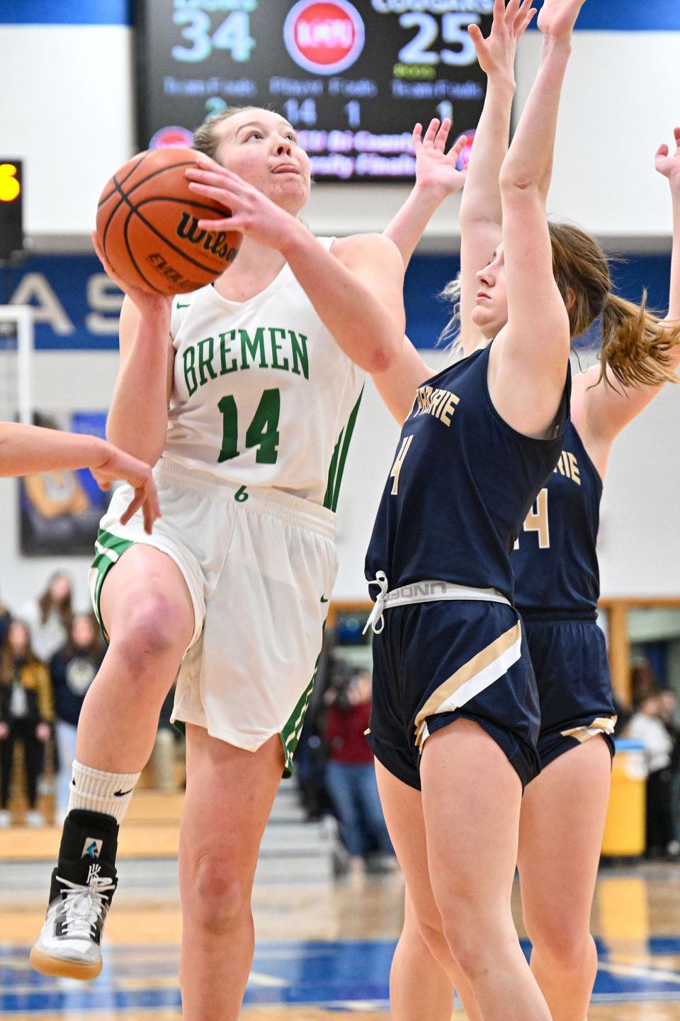 Bremen’s Katie Moyer (14) goes up for a shot as New Prairie’s Eva Dodds (4) defends in the third quarter of the TCU Bi-County Girls Varsity Finals Saturday, Jan. 22, 2022, at LaVille High School.