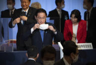 Japan's former Foreign Minister Fumio Kishida, center, puts on his face mask as he leaves the stage after winning the Liberal Democrat Party leadership election in Tokyo Wednesday, Sept. 29, 2021. Kishida won the governing party leadership election on Wednesday and is set to become the next prime minister, facing the imminent task of addressing a pandemic-hit economy and ensuring a strong alliance with Washington to counter growing regional security risks. (Carl Court/Pool Photo via AP)