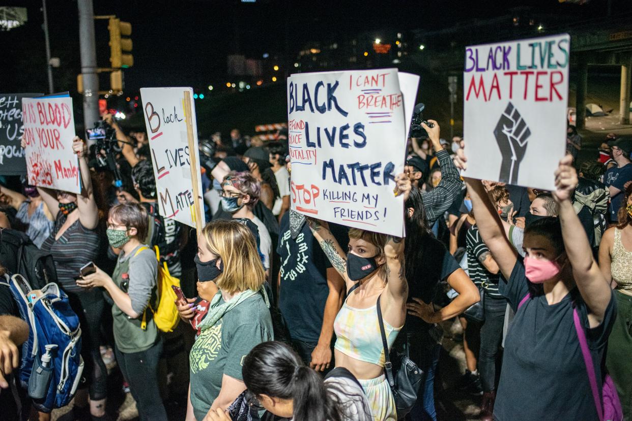 Demonstrators in Austin, Texas, hold up Black Lives Matter signs on 26 July, 2020. (Getty Images)