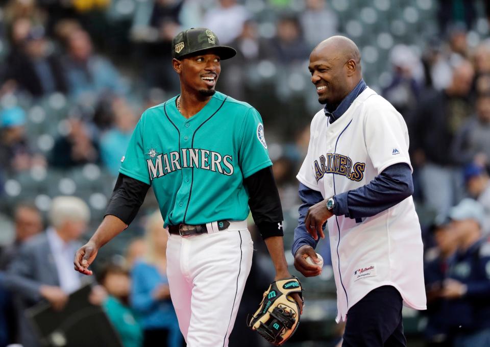 Seattle Mariners' Dee Gordon, left, laughs with  Harold Reynolds before a game on May 17, 2019, in Seattle.