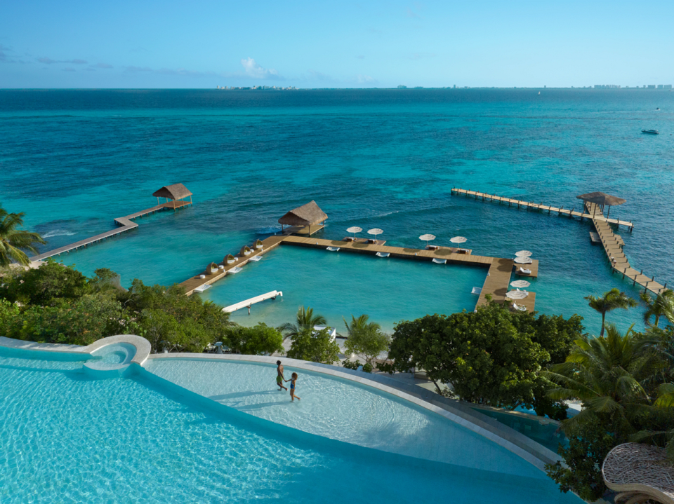 The dock wraps around the resort's oceanfront, creating a calm swimming area.