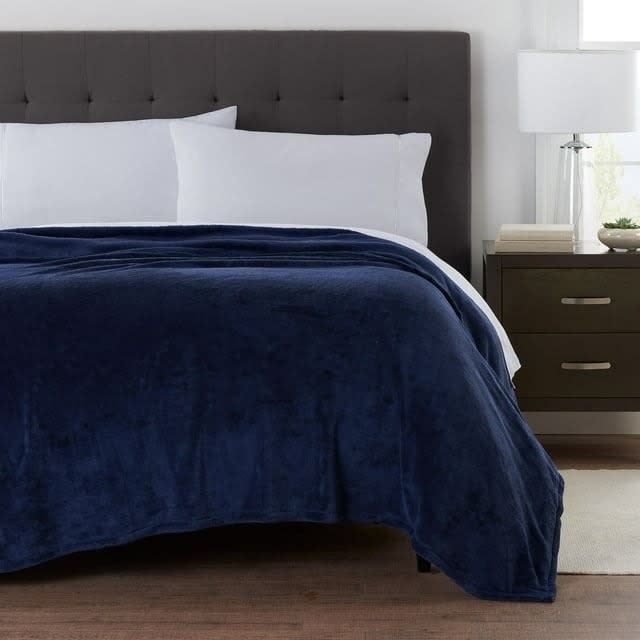 the navy blue blanket on a bed