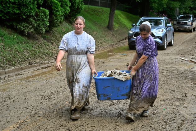 Volunteers from the local mennonite community carry tubfulls of debris from flood soaked houses for disposal at Ogden Hollar in Hindman, Kentucky, on July 30. (Photo: Timothy D. Easley/AP)