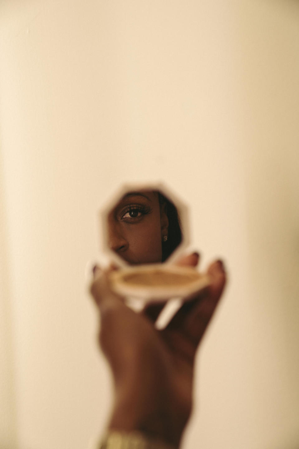 Tiffany Mitchell, jugadora de Indiana Fever de la WNBA (la división femenina de la NBA), reflejada en un estuche de maquillaje en el vestuario del equipo, en Indianápolis. (Gabriella Angotti-Jones/The New York Times)