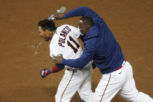 Minnesota Twins' Jorge Polanco, left, gets a water dousing from Miguel Sano following his game-winning RBI single off Milwaukee Brewers pitcher David Phelps in the 12th inning of a baseball game Tuesday, Aug. 18, 2020, in Minneapolis. (AP Photo/Jim Mone)