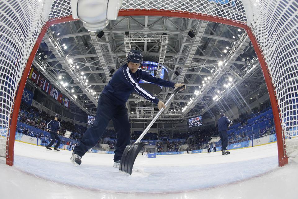 Volunteers refresh the ice during a break in the action in the game between Switzerland and Finland during the 2014 Winter Olympics women's ice hockey game at Shayba Arena, Wednesday, Feb. 12, 2014, in Sochi, Russia. (AP Photo/Matt Slocum, Pool)