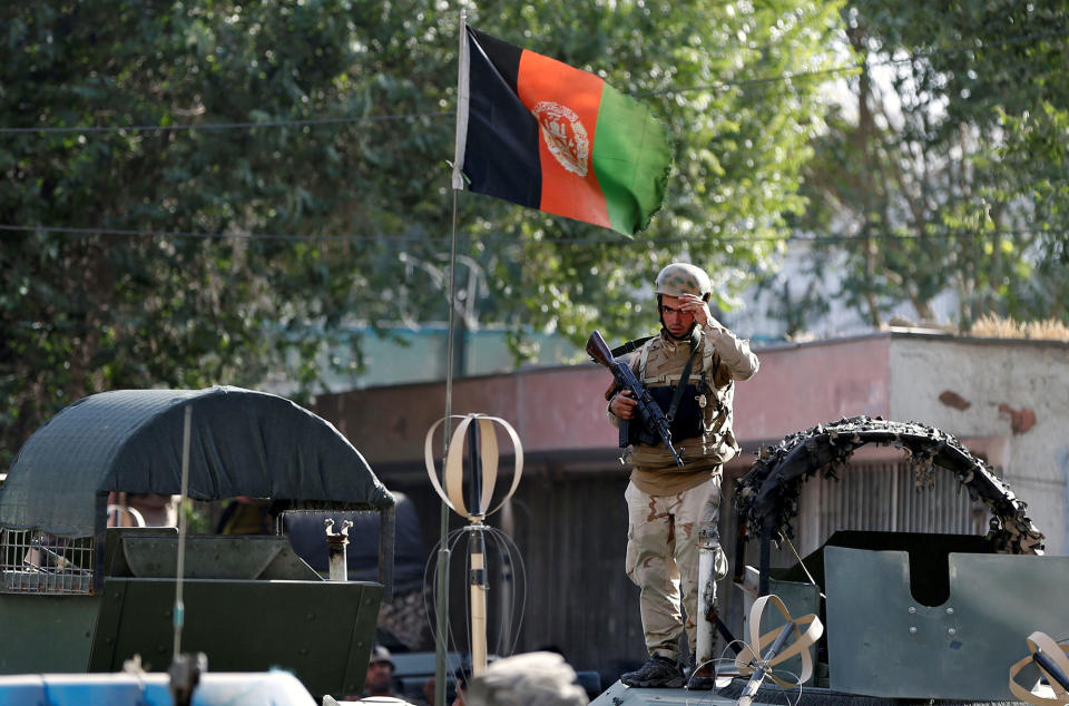 <p>Security force member stands over a military car before leaving the site of a suicide attack followed by a clash between Afghan forces and insurgents after an attack on Iraq embassy in Kabul, Afghanistan, July 31, 2017. (Omar Sobhani/Reuters) </p>