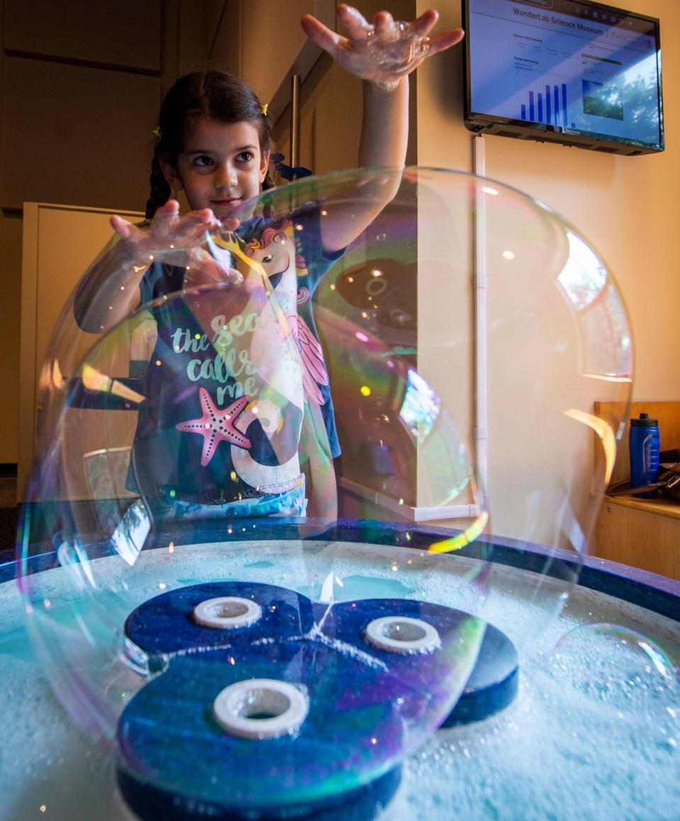 Nil Zeynep Ocal plays with a bubble making machine during BubbleFest at WonderLab Science Museum on Saturday, June 17, 2023.