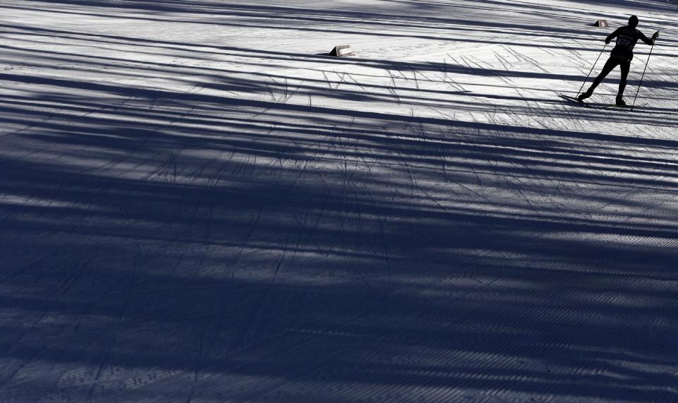 A skier is silhouetted during a biathlon training session at the 2014 Winter Olympics, Friday, Feb. 7, 2014, in Krasnaya Polyana, Russia. (AP Photo/Kirsty Wigglesworth)