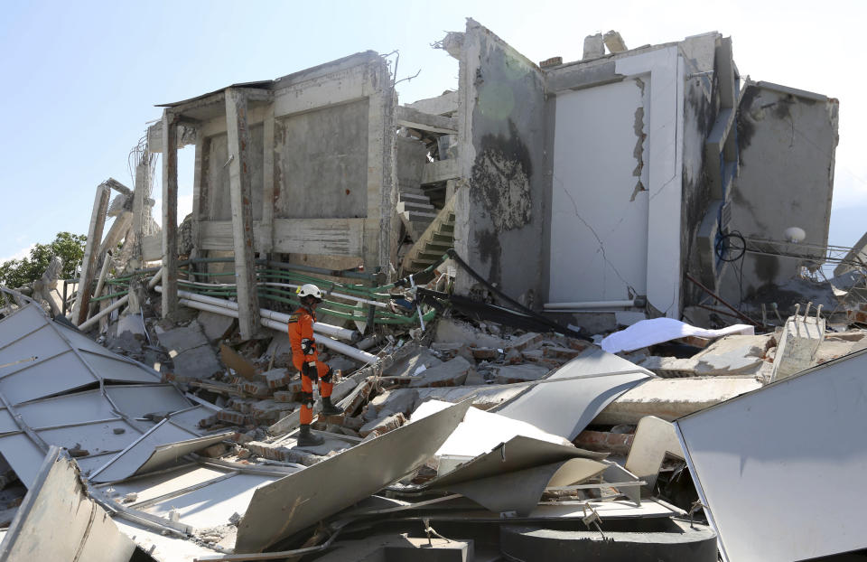 In this Sunday, Sept. 30, 2018, file photo, a rescuer inspects the damage of Roa-Roa Hotel following a massive earthquake and tsunami in Palu, Central Sulawesi, Indonesia. (AP Photo/Tatan Syuflana, File)