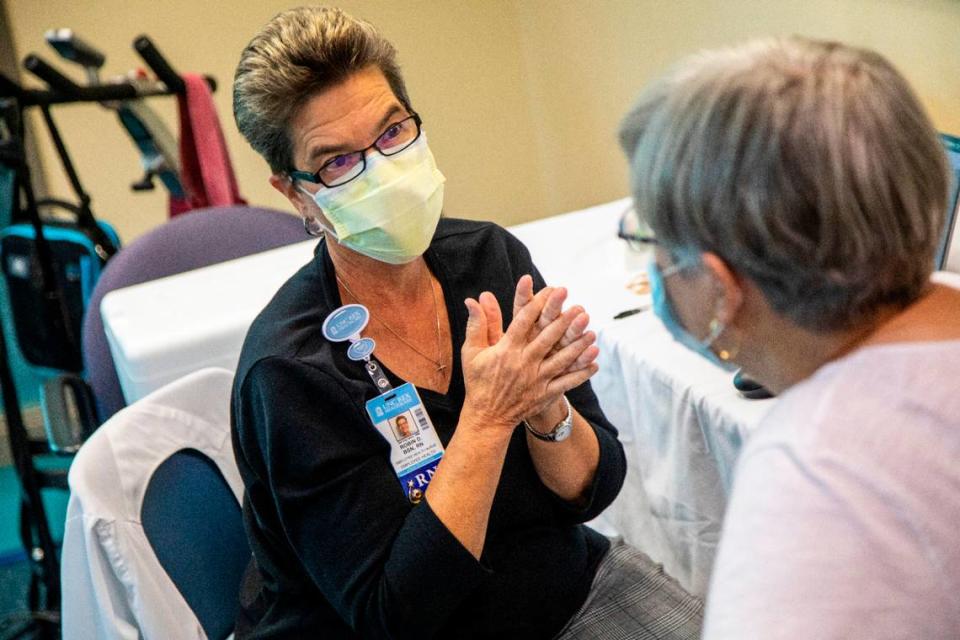 Robin Deal, a retired registered nurse, left, prepares to administer a flu shot to Susan Grant at Rex Wellness Center of Cary Thursday, Oct. 14, 2021. By giving flu shots this fall, Deal is helping other Rex respond to the COVID-19 pandemic.