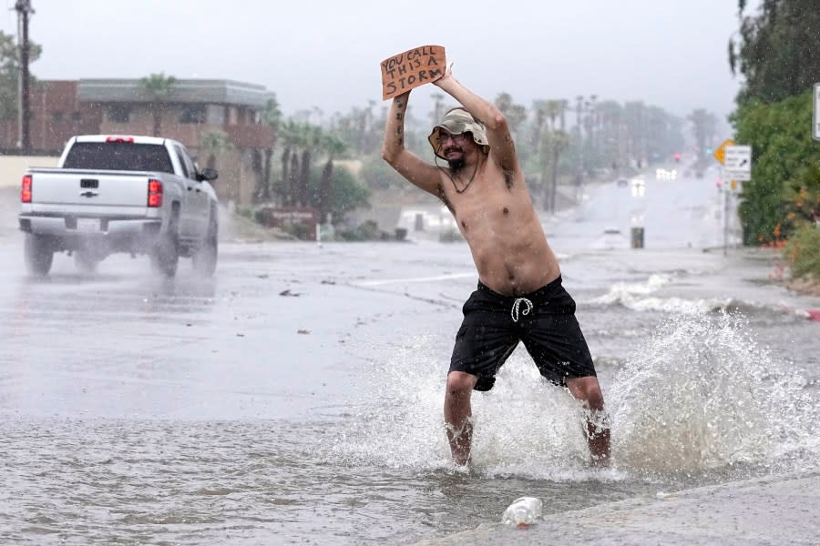 Joseph Wolensky stands in the street with a sign that says "You call this a storm?" Sunday, Aug. 20, 2023, in Palm Desert, Calif. Forecasters said Tropical Storm Hilary was the first tropical storm to hit Southern California in 84 years, bringing the potential for flash floods, mudslides, isolated tornadoes, high winds and power outages. (AP Photo/Mark J. Terrill)