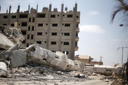 The damaged minaret of a mosque, which witnesses said was hit in an Israeli air strike during the Israeli offensive, is seen during Friday prayers in Gaza City August 22, 2014. REUTERS/Suhaib Salem