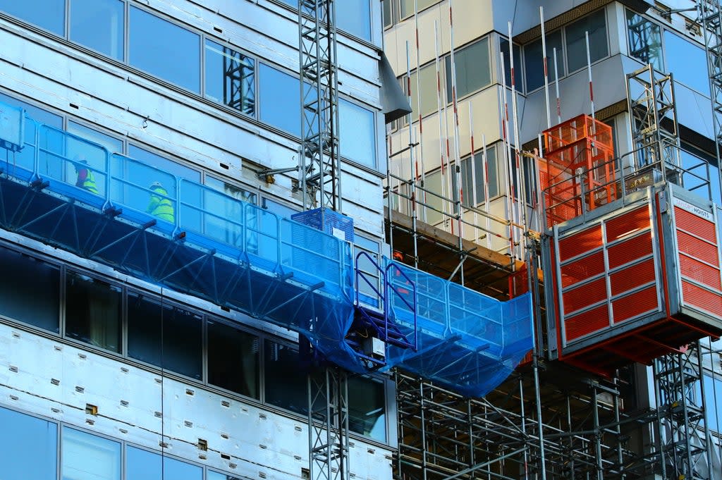 Workmen remove the cladding from the facade of a block of flats in Paddington, north London (Aaron Chown/PA) (PA Wire)