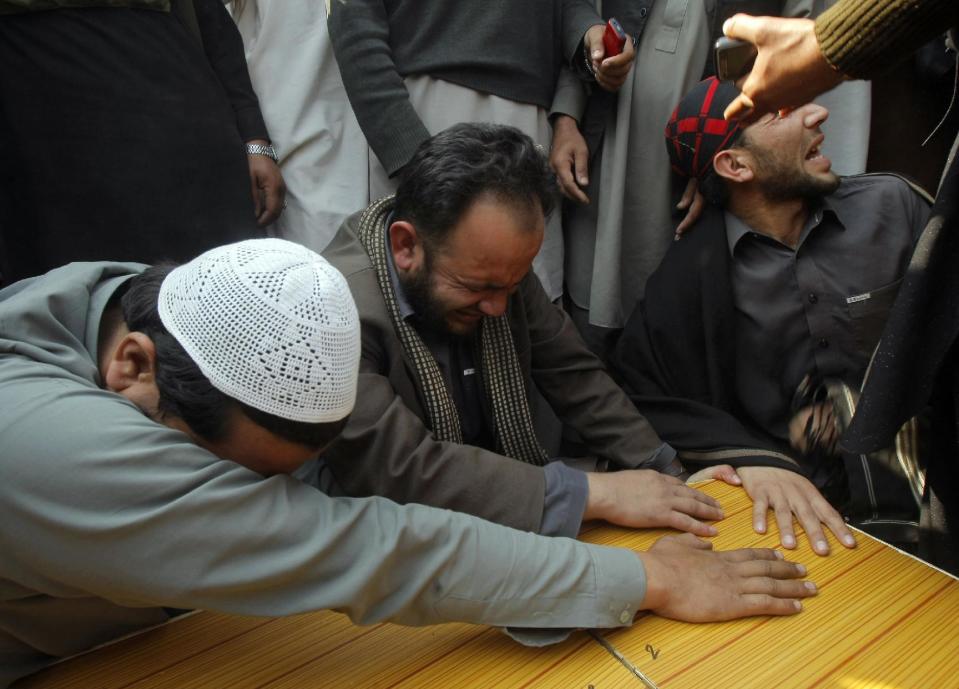 Relatives of a Pakistani, who was killed in a bomb blast, mourn over his casket during their funeral, in Jamrud, near Peshawar, Pakistan, Saturday, March 1, 2014. The Pakistani Taliban announced Saturday that the group will observe a one-month cease-fire as part of efforts to negotiate a peace deal with the government, throwing new life into a foundering peace process. The violence Saturday showed how difficult it could be to enforce a cease-fire, let alone forge a peace agreement. (AP Photo/Mohammad Sajjad)