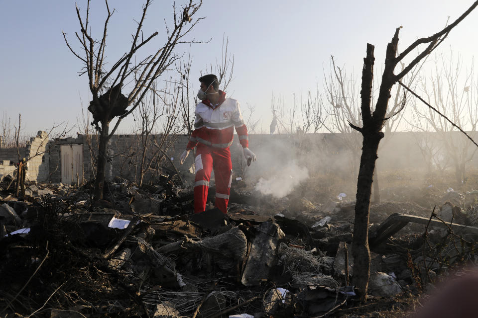 A rescue worker searches the scene where an Ukrainian plane crashed in Shahedshahr, southwest of the capital Tehran, Iran, Wednesday, Jan. 8, 2020. A Ukrainian airplane carrying 176 people crashed on Wednesday shortly after takeoff from Tehran's main airport, killing all onboard. (AP Photo/Ebrahim Noroozi)