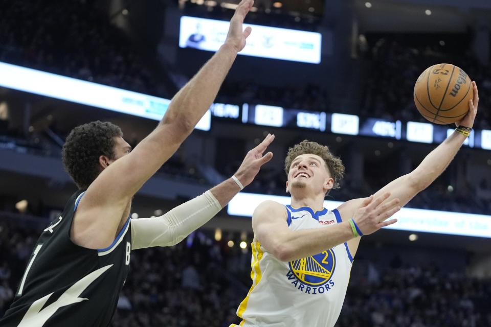 Golden State Warriors' Brandin Podziemski tries to shoot past Milwaukee Bucks' Brook Lopez during the second half of an NBA basketball game Saturday, Jan. 13, 2024, in Milwaukee. The Bucks won 129-118. (AP Photo/Morry Gash)