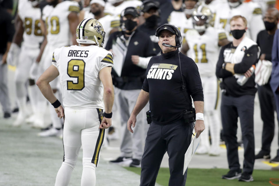 FILE - In this Sept. 21, 2020 file photo, New Orleans Saints head coach Sean Payton, right, speak with quarterback Drew Brees (9) during the first half of an NFL football game against the Las Vegas Raiders, in Las Vegas. The NFL has fined the New Orleans Saints $500,000 and stripped them of a 2021 seventh-round draft pick for violating league COVID-19 protocols, a person with direct knowledge of the discipline told The Associated Press on Sunday, Nov. 29. New Orleans was fined as a repeat offender; Payton previously was docked $150,000 and the team $250,000 because the head coach failed to properly wear a face covering against the Raiders in Week 2. (AP Photo/Isaac Brekken, File)