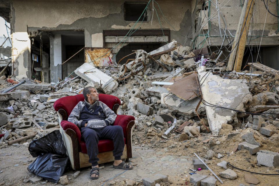 A Palestinian man sits in an armchair outside a destroyed building in Gaza City on Wednesday, Nov. 29, 2023, the sixth day of the temporary cease-fire between Hamas and Israel. (AP Photo/Mohammed Hajjar)