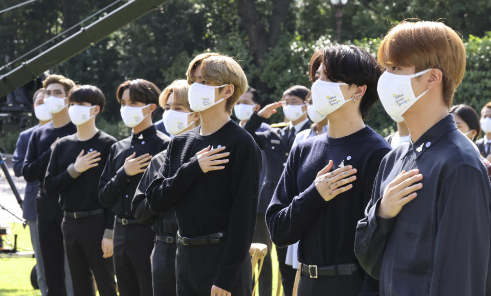 La banda sudcoreana BTS saluda su bandera nacional durante una ceremonia para conmemorar el Día Nacional de la Juventud en la Casa Azul presidencial en Seúl, Corea del Sur, el 19 de septiembre de 2020. Nacionalistas chinos critican a la boy band sudcoreana BTS por una declaración del cantante RM quien agradeció a los veteranos de la Guerra de Corea. (Lee Jin-wook/Yonhap via AP)