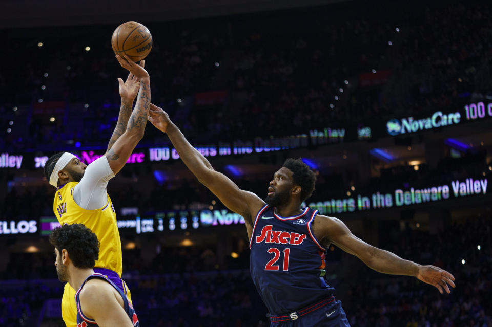 Los Angeles Lakers' Anthony Davis, left, shoots the ball with Philadelphia 76ers' Joel Embiid, right, defending during the first half of an NBA basketball game, Thursday, Jan. 27, 2022, in Philadelphia. (AP Photo/Chris Szagola)