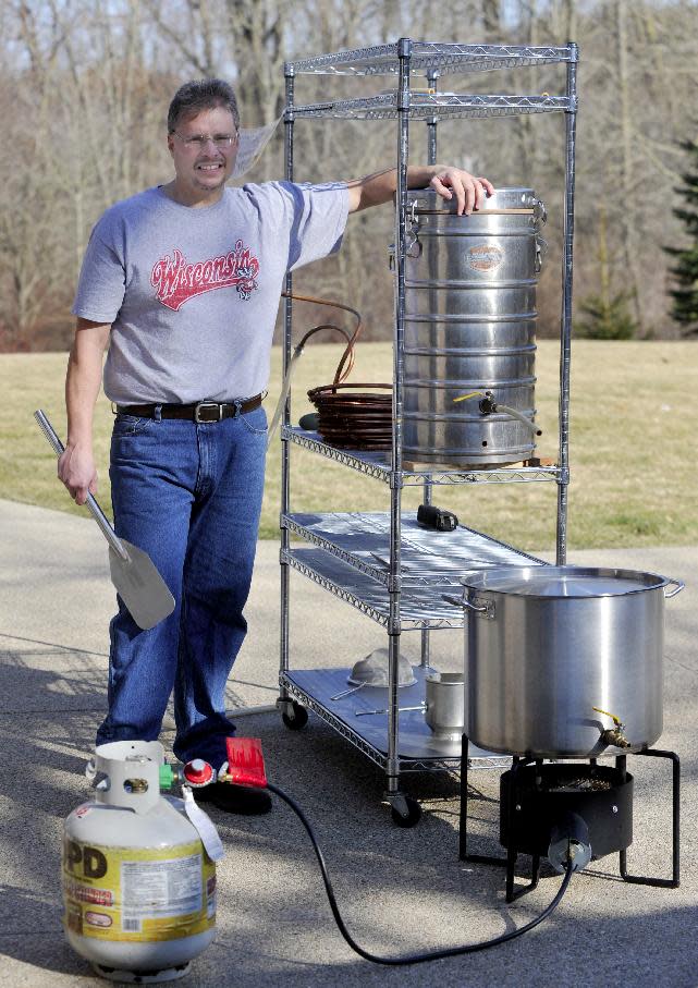 In this March 10, 2012 photo, Kevin Flynn, 46, of Caledonia, Wis., poses with some of his home brewing equipment. An explosion of interest in home beer brewing is forcing lawmakers across the country to review long-forgotten alcohol laws, some of which date back to Prohibition. (AP Photo/Journal Times, Gregory Shaver)