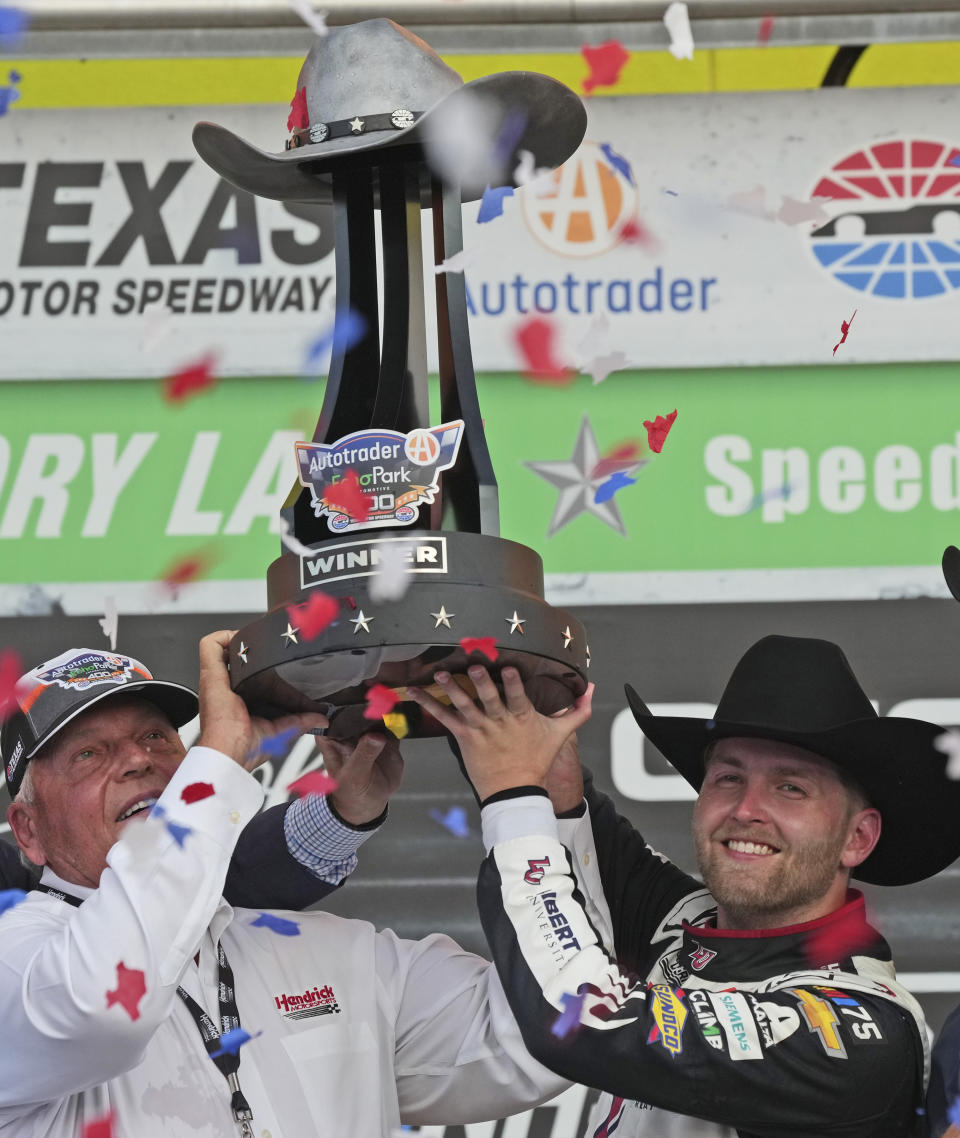 William Byron, right, and team owner Rick Hendrick hold up the trophy after winning the NASCAR Cup Series auto race at Texas Motor Speedway in Fort Worth, Texas, Sunday, Sept. 24, 2023. (AP Photo/LM Otero)