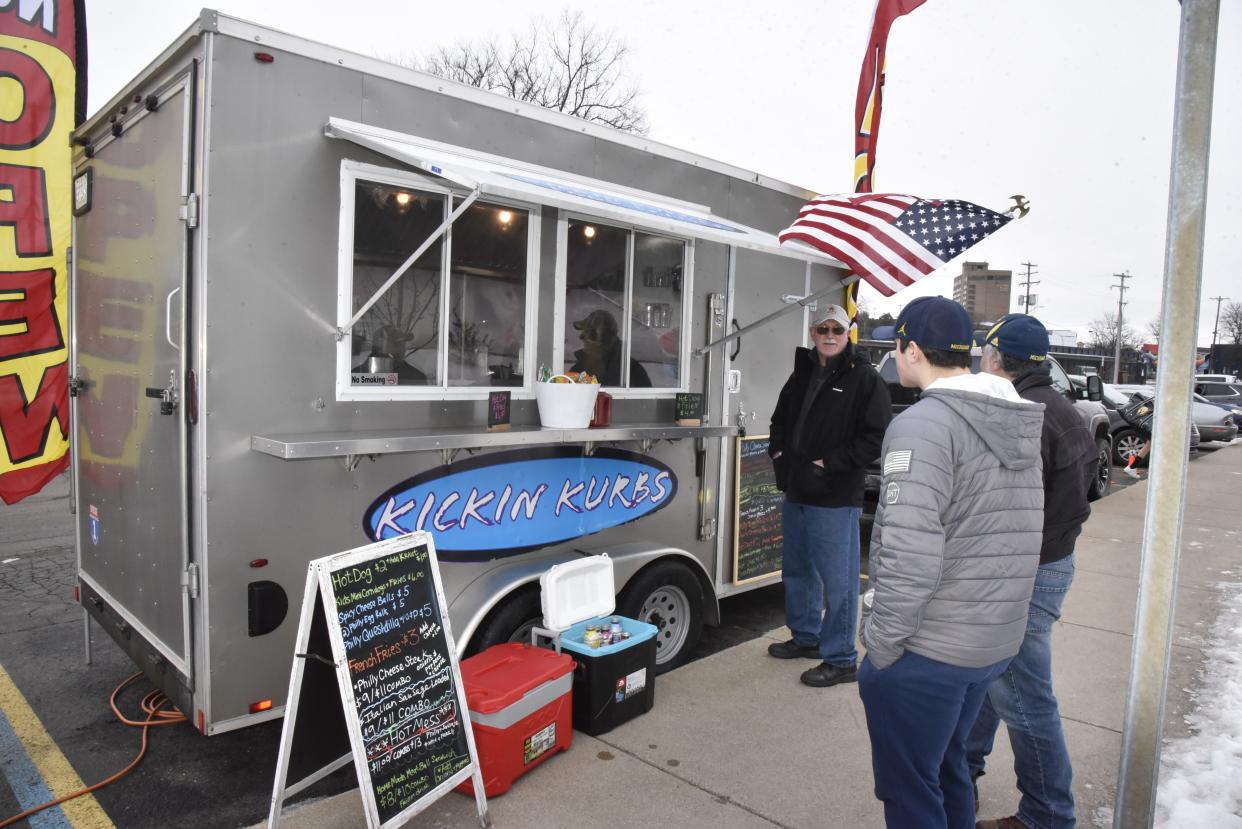 Customers wait for their orders from Kickin Kurbz food truck in the parking lot of The Rink in downtown Battle Creek on Friday, Jan. 14, 2022.