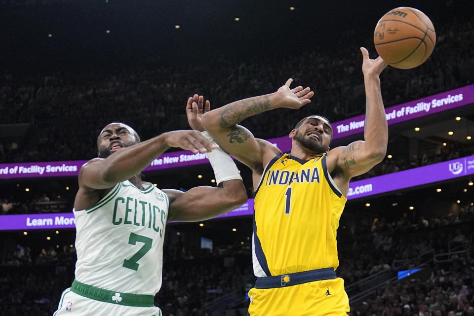 Boston Celtics guard Jaylen Brown (7) and Indiana Pacers forward Obi Toppin (1) battle for a rebound during the second quarter of Game 1 of the NBA Eastern Conference basketball finals, Tuesday, May 21, 2024, in Boston. (AP Photo/Charles Krupa)