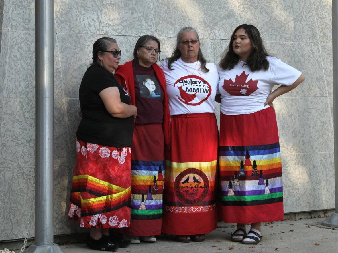 Debbie Gallagher, second from right, stands besides loved ones at a vigil in Saskatoon Tuesday for missing and murdered Indigenous women, girls, and gender-diverse people. Gallagher's stepdaughter went missing about two years ago.   (Courtney Markewich/CBC - image credit)