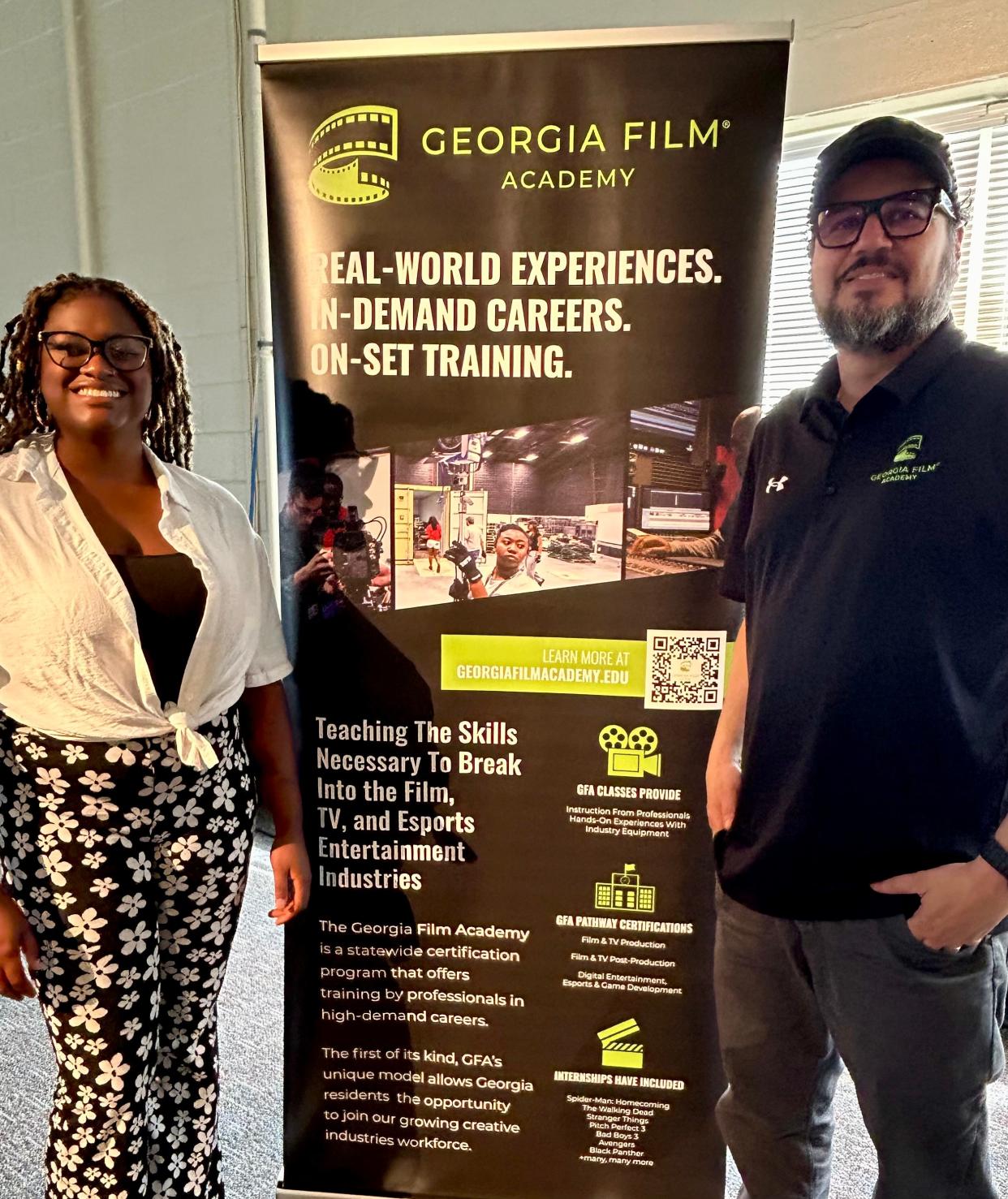 Georgia Film Academy (GFA) Instructional South Georgia Region Manager Julio Saldarriaga and GFA alumna Brianna Black pose before a promotional banner on May 14, 2024 at Savannah State University where GFA will hold eight-week summer courses start May 21.