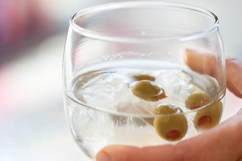 martini with olives in glass