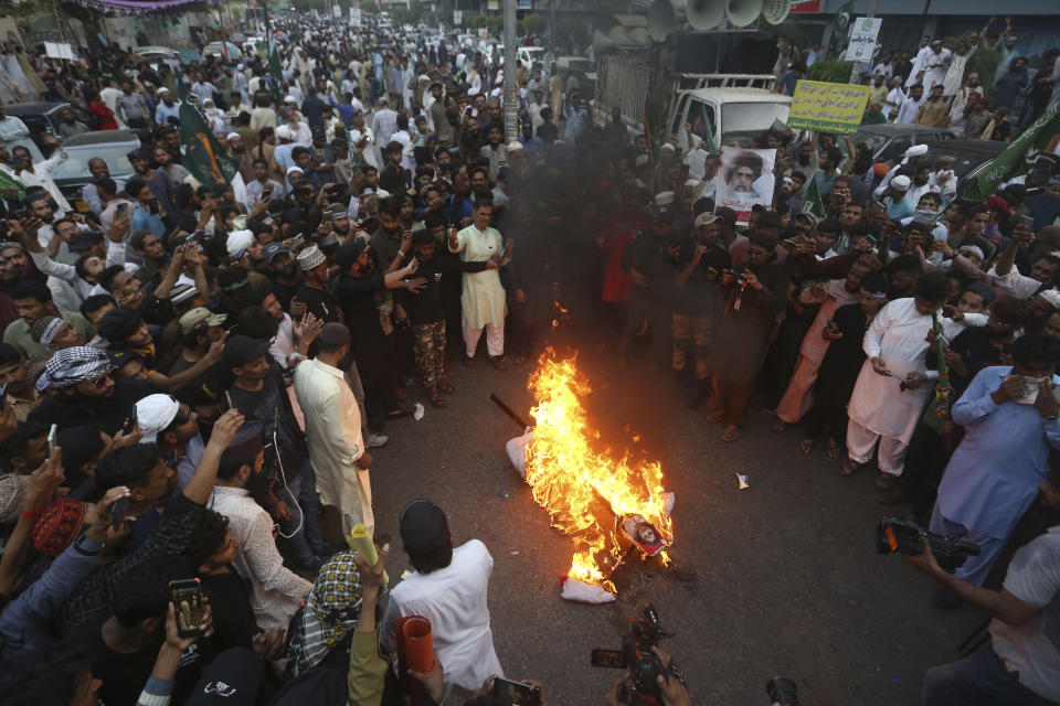 Supporters of a Pakistani religious group burn an effigy depicting former Bharatiya Janata Party spokeswoman Nupur Sharma during a demonstration to condemn derogatory references to Islam and the Prophet Muhammad recently made by Sharma, Friday, June 10, 2022, , in Karachi, Pakistan. (AP Photo/Fareed Khan)