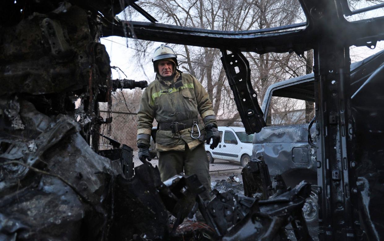 A firefighter examines a burned car after a shelling by Ukrainian forces in Donetsk - Alexei Alexandrov/AP