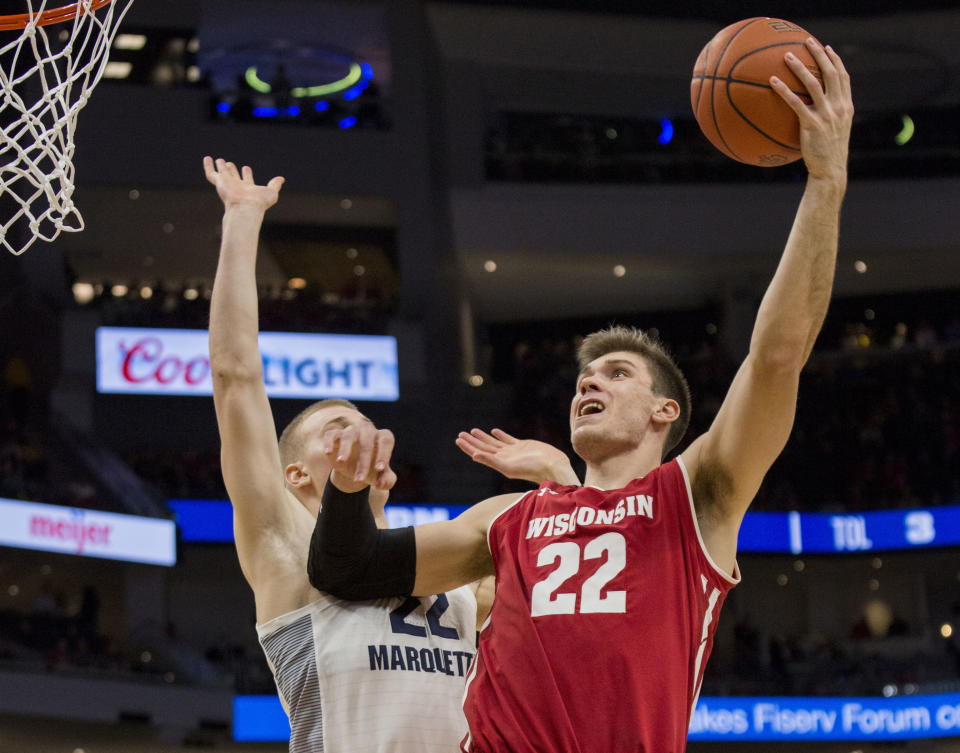 FILE - In this Dec. 8, 2018, file photo, Wisconsin forward Ethan Happ, right, goes up for a basket against Marquette forward Joey Hauser during the second half of an NCAA college basketball game, in Milwaukee. Happ was named to the AP All-Big Ten Conference team, Tuesday, March 12, 2019. (AP Photo/Darren Hauck, File)